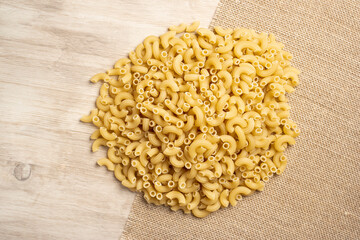 Dry uncooked pasta on a wood  kitchen table