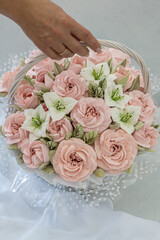 Zephyr bouquet of flowers in a wicker basket on a light background.