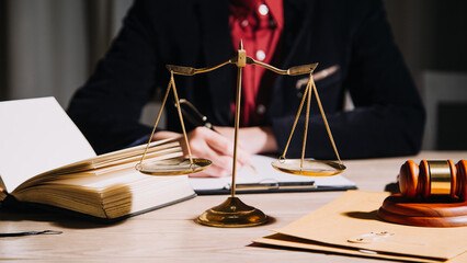 Justice and law concept.Male judge in a courtroom with the gavel, working with, computer and docking keyboard, eyeglasses, on table in morning light