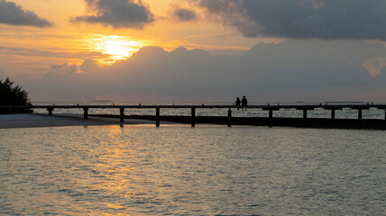 A COUPLE IN A WONDERFUL VIEW OF THE MALDIVIAN SUNSET 