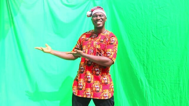 Cultural red clothes dressed tribal man in marketing presentation and gesturing to a product at the right, left or side ending with an approval thumb up for marketing adverts