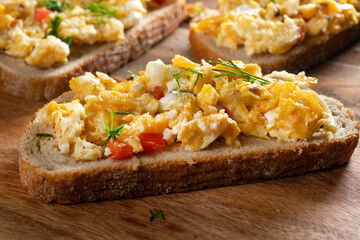 Scrambled eggs on a slice of bread.