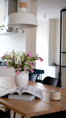 Modern living room with table and chairs. Stylish dinning room with wooden table and chairs. Kitchen interior with furniture. Living room with blossom in white vase