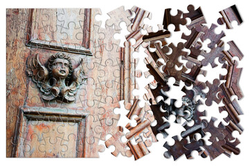The slow construction of faith - concept image with a sculpture of an angel on a wooden door in jigsaw puzzle shape