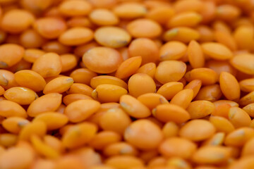 Pile of red lentils as background, legume as background. close-up of raw red lentils
