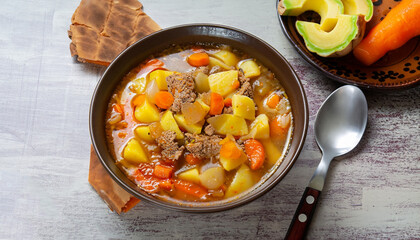 Meat soup Estofado with potatoes, carrots and seasonings. Traditional Mexican dishes. Selective focus. Top view.