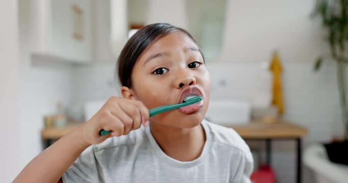 Face of girl, child and brushing teeth in bathroom for dental wellness, morning routine and healthy habits. Portrait of young kid cleaning mouth with toothbrush, self care and fresh breath at home