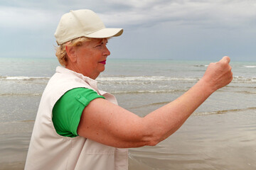 Senior woman doing sport to keep fit. Mature woman running along the shore of the beach. Concept of...