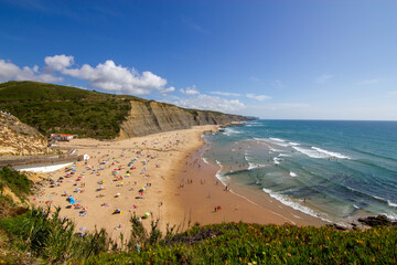 Praia do Magoito, Portugal. 
Vista sobre a praia e mar, com pessoas na praia. Céu limpo e bom tempo de praia. 