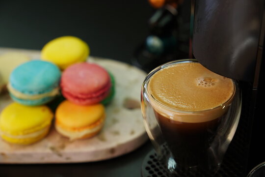 coffee from machine with alfajores and macaroon biscuits