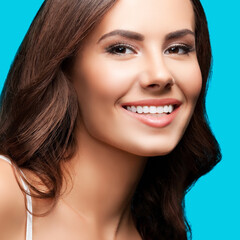 Fototapeta premium Portrait of smiling beautiful woman in white casual tank top, over aqua blue green background. Brunette girl at studio concept. Square composition.