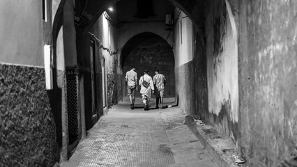 Moroccan Young Men Walking in Alley at night. Marrakesh 