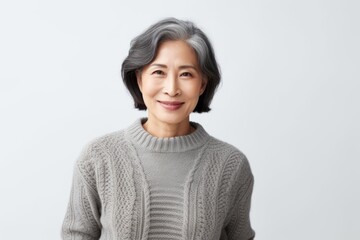 Obraz premium Portrait of a smiling senior asian woman standing against white background