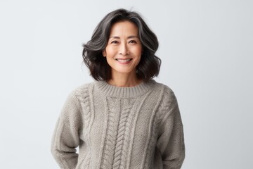 Obraz premium Portrait of a smiling asian woman in sweater standing against white background