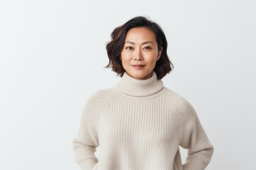 Portrait of a happy asian woman in sweater looking at camera over white background
