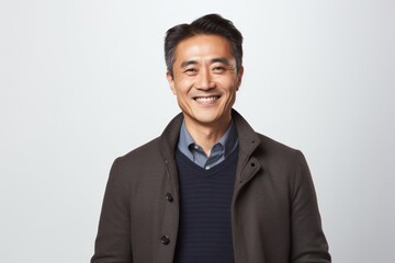 Portrait of a happy mature asian man smiling against white background