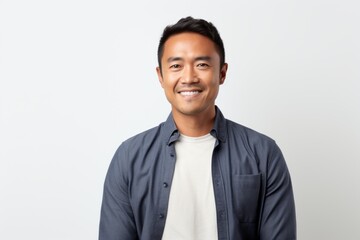 Portrait photography of a pleased Indonesian man in his 30s wearing a chic cardigan against a white background 