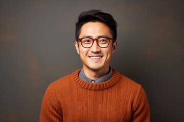 Fototapeta premium Portrait photography of a satisfied Chinese man in his 30s wearing a cozy sweater against an abstract background 