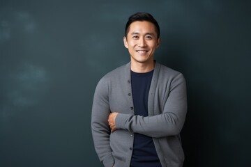 Obraz premium Portrait photography of a pleased Chinese man in his 30s wearing a chic cardigan against an abstract background 