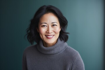 Fototapeta premium Portrait photography of a happy Chinese woman in her 40s wearing a cozy sweater against an abstract background 