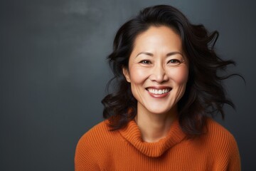 Portrait photography of a happy Chinese woman in her 40s wearing a cozy sweater against an abstract background 