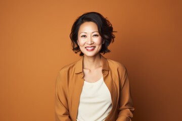 Portrait photography of a pleased Chinese woman in her 40s wearing a chic cardigan against an abstract background 
