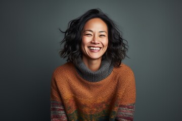 Fototapeta premium Portrait photography of a happy Chinese woman in her 40s wearing a cozy sweater against an abstract background 