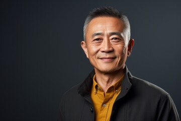 Fototapeta premium Portrait photography of a satisfied Chinese man in his 50s wearing a chic cardigan against an abstract background 