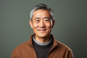 Fototapeta premium Portrait photography of a satisfied Chinese man in his 50s wearing a chic cardigan against an abstract background 