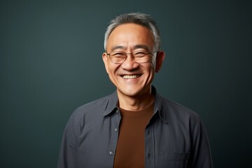 Fototapeta premium Portrait photography of a happy Chinese man in his 50s wearing a chic cardigan against an abstract background 