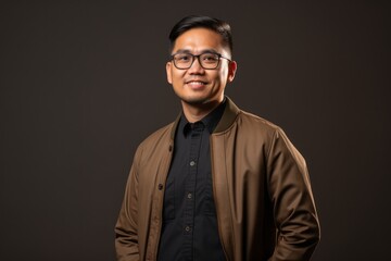 Obraz premium Portrait photography of a pleased Indonesian man in his 30s wearing a chic cardigan against an abstract background 