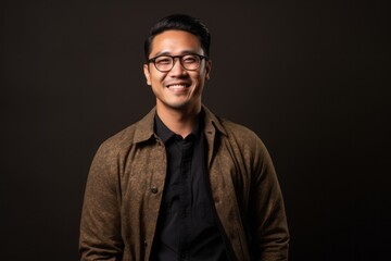 Obraz premium Portrait photography of a pleased Indonesian man in his 30s wearing a chic cardigan against an abstract background 