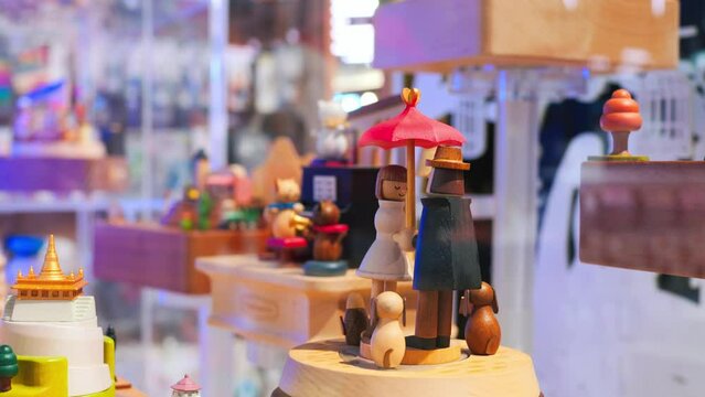 Spinning wooden toys on a storefront. Cinematic video of music box, spinning wooden toys on a storefront. Slow motion wooden toys on a storefront are spinning on a music box and waiting for children.