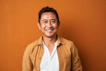 Fototapeta premium Portrait photography of a cheerful Indonesian man in his 40s wearing a chic cardigan against an abstract background 