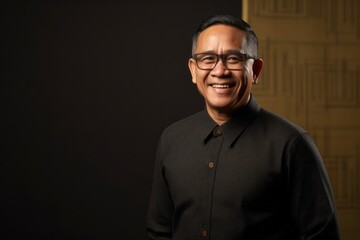 Obraz premium Portrait photography of a pleased Indonesian man in his 50s wearing a chic cardigan against an abstract background 