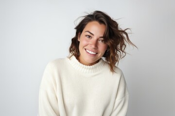 Fototapeta premium Portrait of a smiling young woman in white sweater on white background