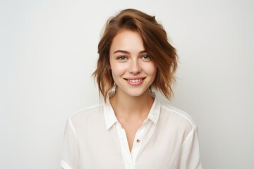 Obraz premium Portrait of a beautiful young woman in a white shirt on a white background