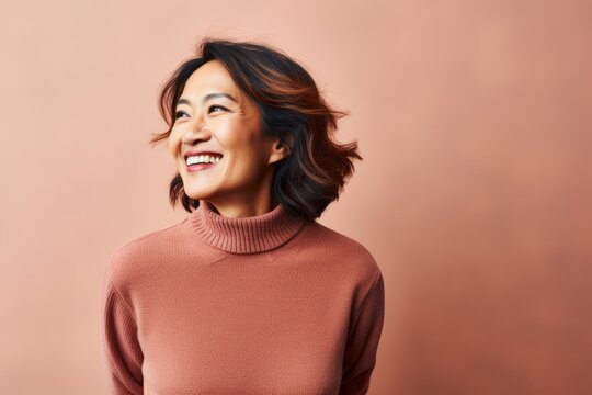 Portrait photography of a pleased Indonesian woman in her 50s wearing a cozy sweater against an abstract background 