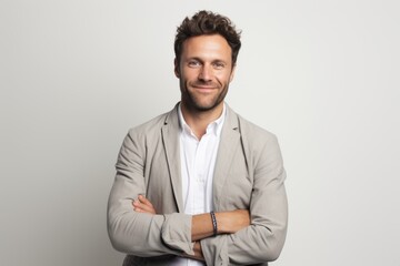 Portrait of a handsome confident businessman standing with arms crossed isolated on a white background