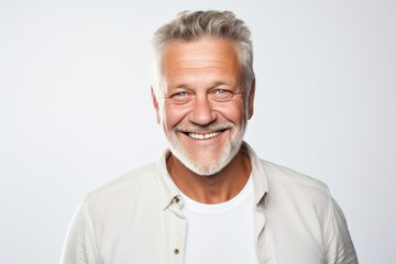 Obraz premium Portrait of a happy senior man smiling at camera over white background