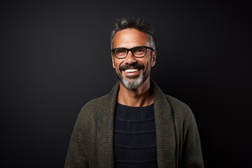Obraz premium Portrait of a smiling man in glasses looking at camera isolated on black background