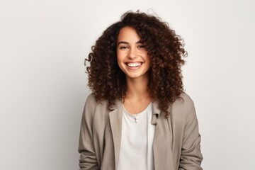Fototapeta premium Portrait of a beautiful young woman with curly hair smiling at camera