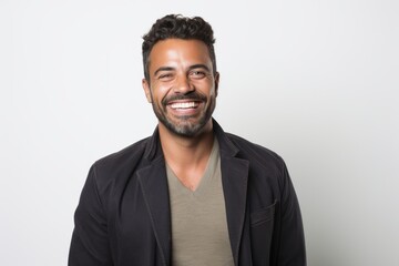 Portrait of a handsome Indian man smiling at the camera over white background