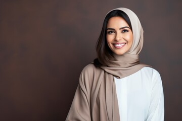 Portrait of a beautiful muslim woman wearing hijab smiling at camera - obrazy, fototapety, plakaty