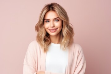 Portrait of a beautiful young blonde woman on a pink background.