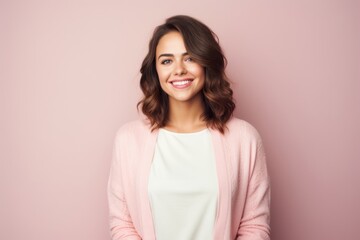 Obraz premium Portrait of a smiling young woman looking at camera over pink background