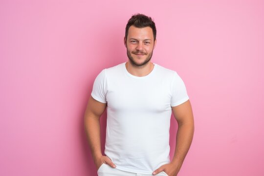 Portrait of a handsome man in white t-shirt on pink background