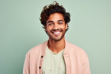 Obraz premium Portrait of a young man with curly hair smiling at camera.