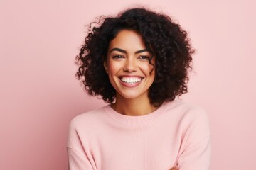 Portrait of a beautiful young african american woman smiling against pink background