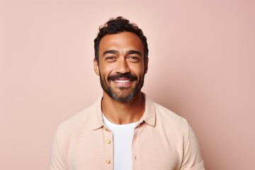 Portrait of a handsome young man smiling and looking at camera isolated over pink background